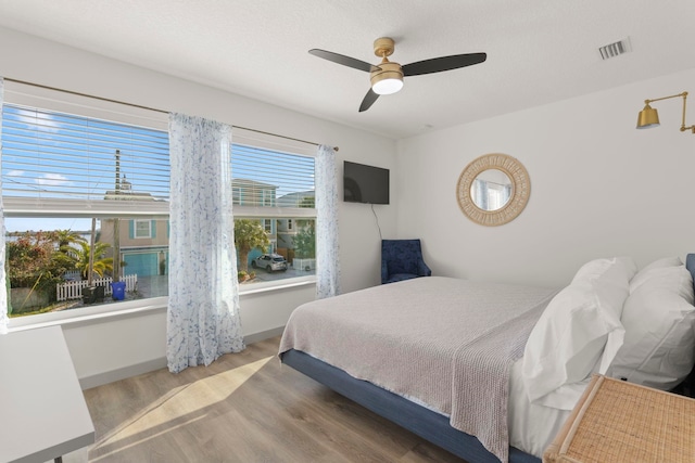 bedroom with ceiling fan and light hardwood / wood-style flooring