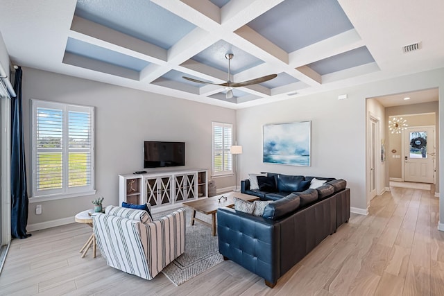 living room featuring beam ceiling, light hardwood / wood-style flooring, a healthy amount of sunlight, and coffered ceiling