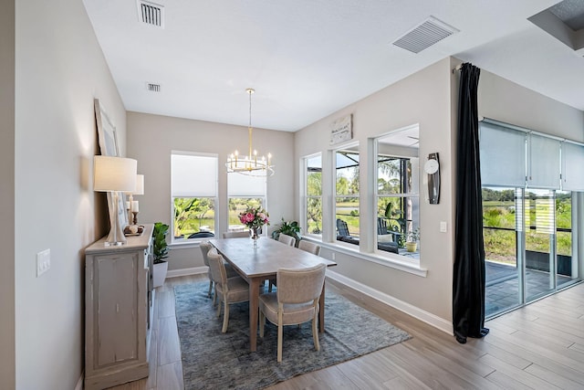 dining room featuring a chandelier, a healthy amount of sunlight, and light wood-type flooring