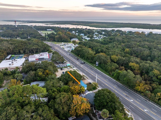 aerial view at dusk featuring a water view