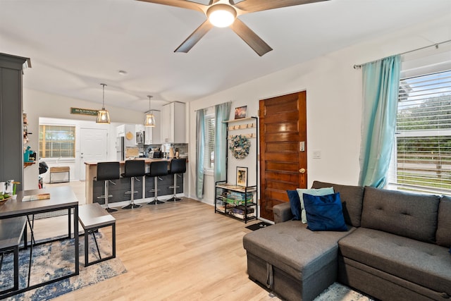 living room with ceiling fan and light wood-type flooring