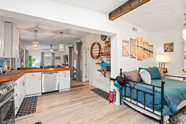 kitchen with sink, white cabinetry, hanging light fixtures, stainless steel appliances, and beam ceiling