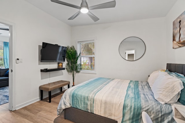 bedroom with vaulted ceiling, ceiling fan, and light wood-type flooring