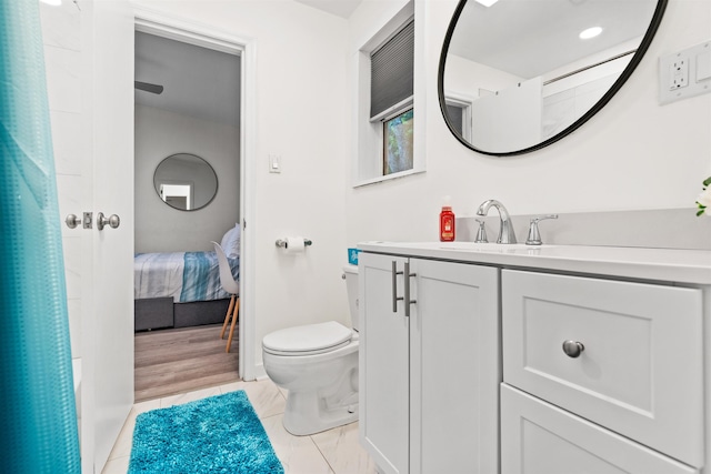 bathroom featuring tile patterned flooring, vanity, and toilet