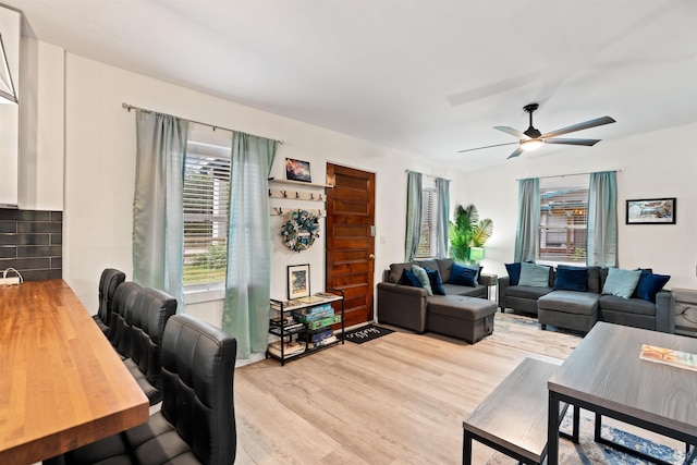 living room with ceiling fan and light hardwood / wood-style flooring