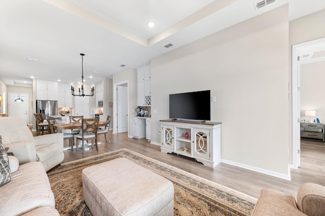 living room featuring a notable chandelier and light hardwood / wood-style floors