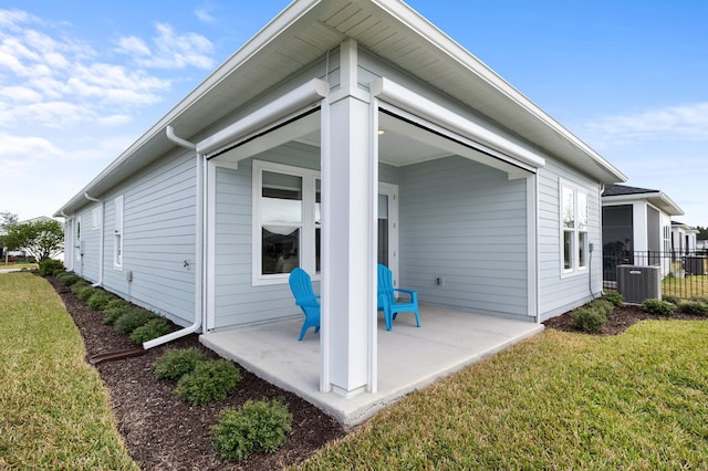 rear view of house featuring a patio, a yard, and central air condition unit