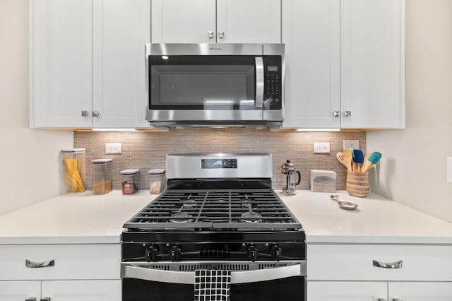 kitchen featuring appliances with stainless steel finishes, white cabinetry, and decorative backsplash