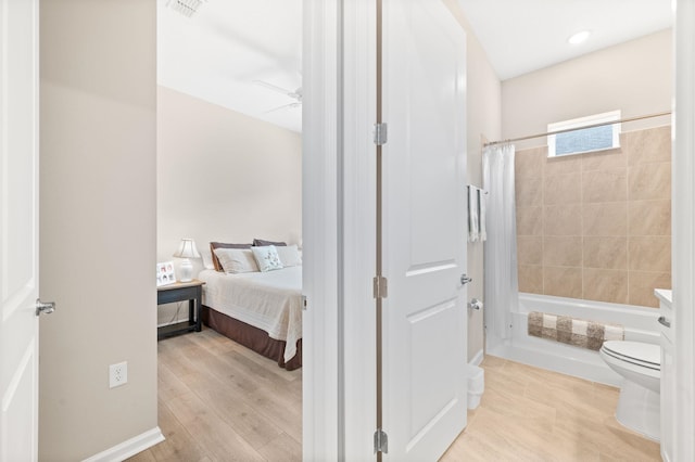 bathroom featuring toilet, hardwood / wood-style flooring, ceiling fan, and shower / bath combination with curtain