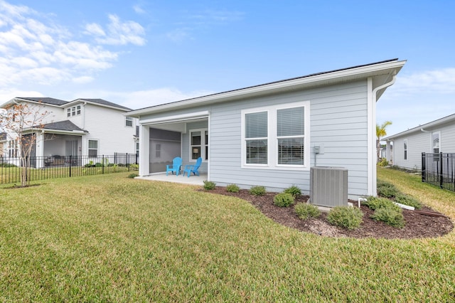 rear view of property featuring a yard, a patio, and cooling unit