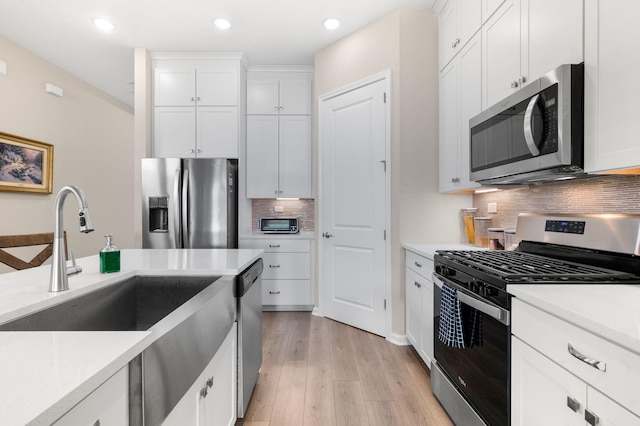 kitchen with white cabinets, stainless steel appliances, and decorative backsplash