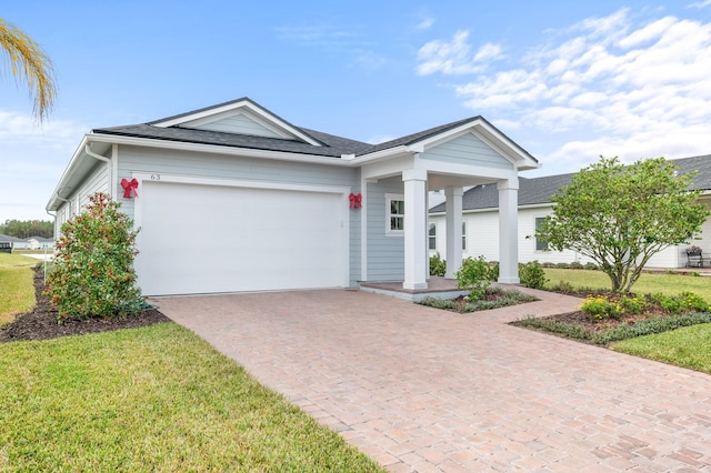 ranch-style home featuring a front lawn and a garage