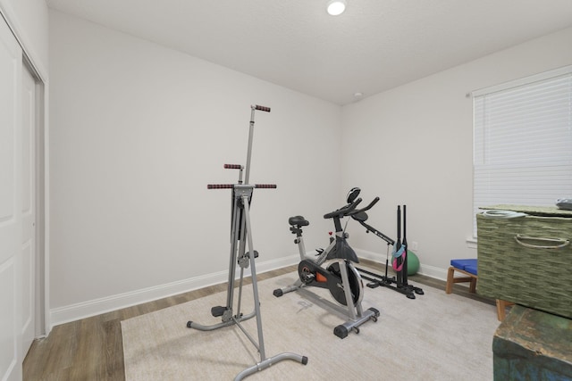 exercise area featuring wood finished floors and baseboards