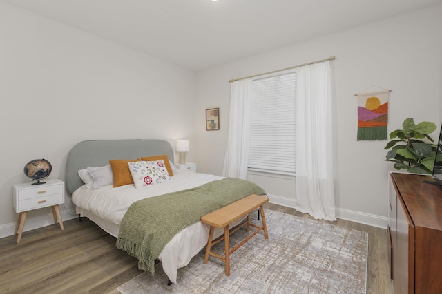 bedroom featuring wood finished floors and baseboards