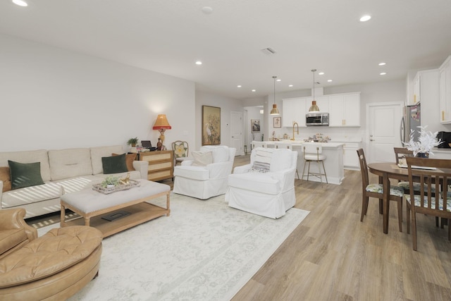 living area featuring light wood finished floors and recessed lighting