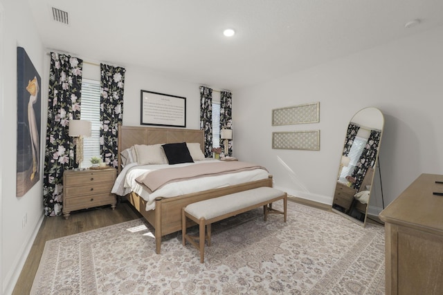 bedroom featuring baseboards, wood finished floors, and recessed lighting