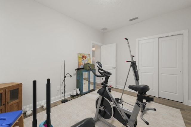 workout room featuring wood finished floors and baseboards