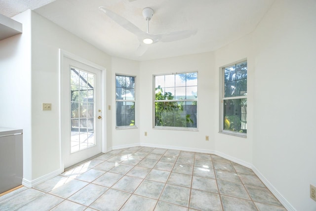 doorway with tile patterned flooring, baseboards, and a ceiling fan