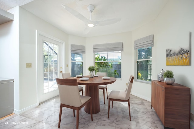 dining room featuring marble finish floor and a healthy amount of sunlight