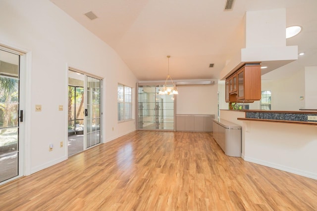 interior space with vaulted ceiling, light wood-style flooring, plenty of natural light, and visible vents