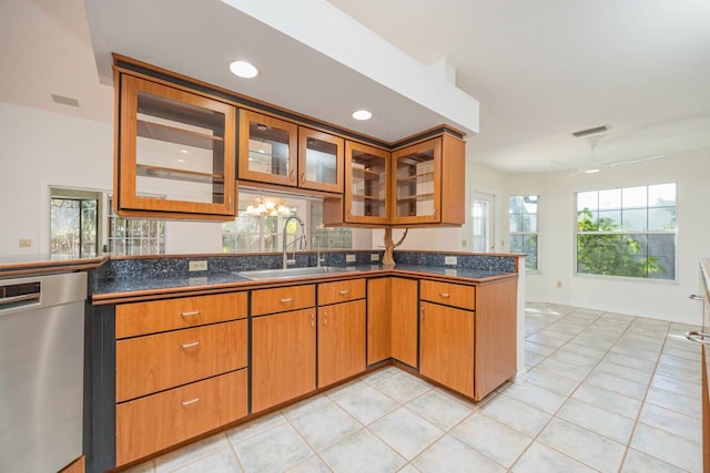 kitchen featuring a sink, visible vents, dishwasher, brown cabinetry, and glass insert cabinets