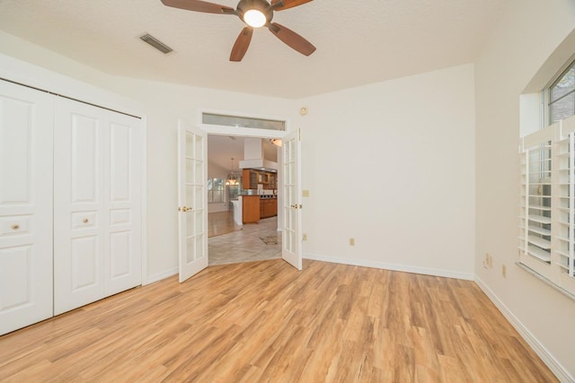 unfurnished bedroom featuring light wood-style flooring, visible vents, baseboards, french doors, and a closet