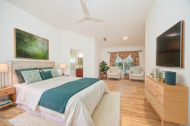 bedroom with light wood-style floors, a ceiling fan, vaulted ceiling, and ensuite bathroom