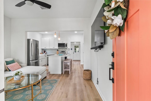interior space with visible vents, baseboards, a ceiling fan, recessed lighting, and light wood-style flooring