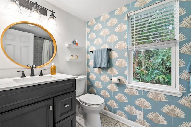 full bath with toilet, wallpapered walls, and vanity