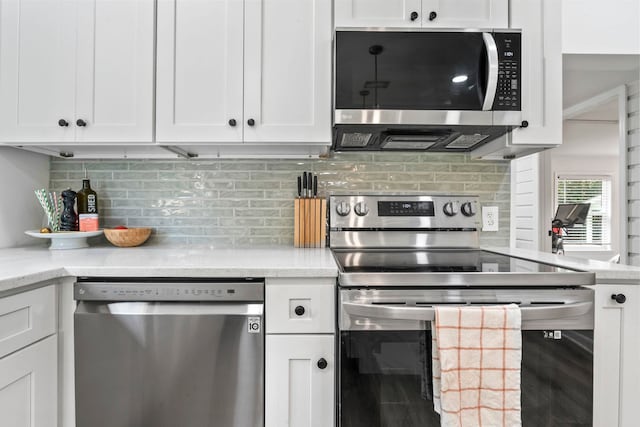 kitchen with appliances with stainless steel finishes, decorative backsplash, and white cabinets