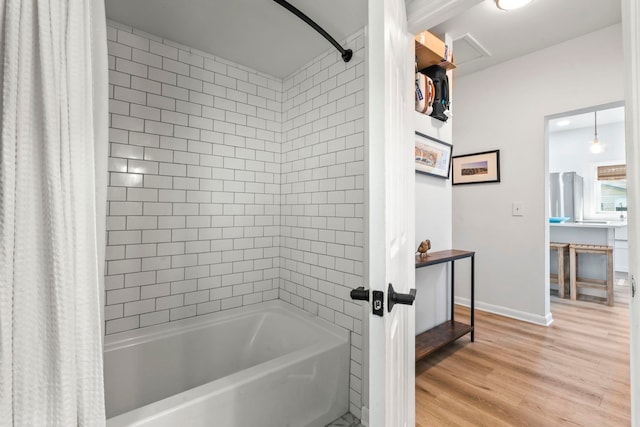 full bathroom featuring baseboards, shower / bathtub combination with curtain, and wood finished floors