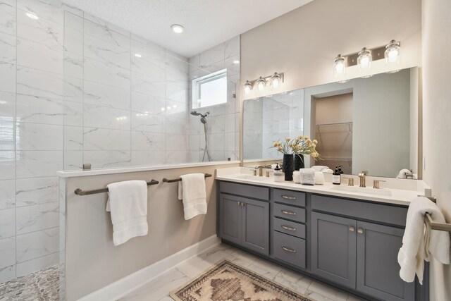 full bath featuring a sink, marble finish floor, and a walk in shower
