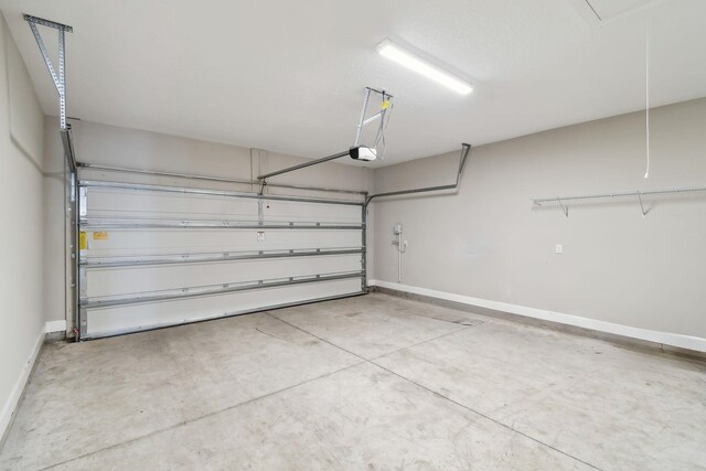 garage with baseboards and a garage door opener