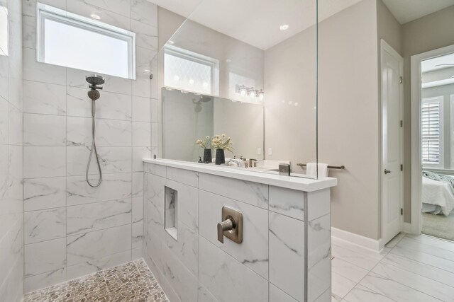 bathroom with ensuite bathroom, a walk in shower, marble finish floor, and a wealth of natural light