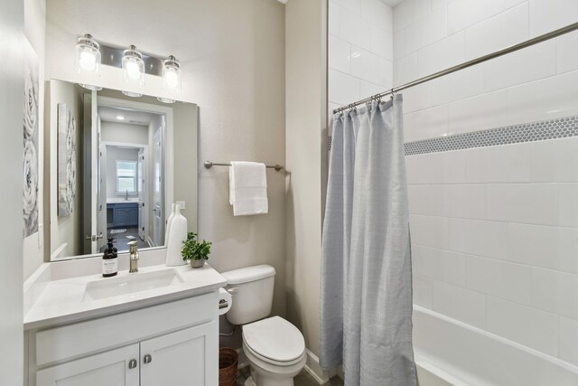 full bath featuring toilet, shower / bath combo, and vanity