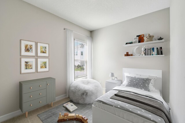 bedroom featuring carpet, baseboards, and a textured ceiling