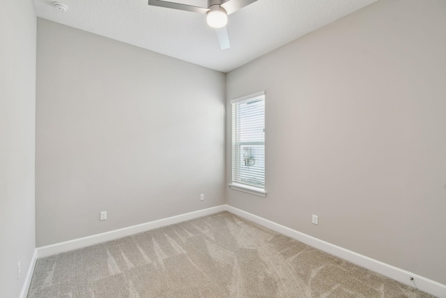 empty room with baseboards, light colored carpet, and ceiling fan