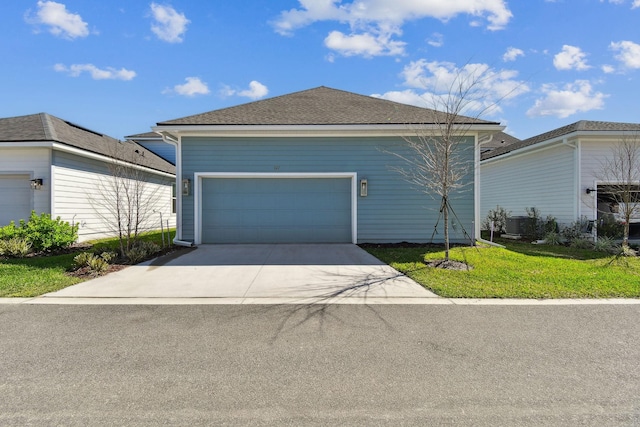 view of front of property with an attached garage, concrete driveway, and a front lawn