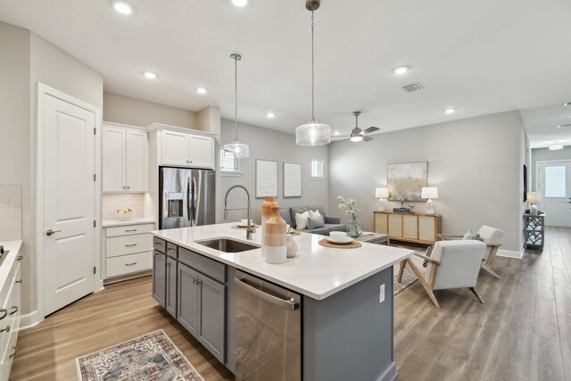 kitchen with visible vents, gray cabinets, a sink, appliances with stainless steel finishes, and white cabinetry
