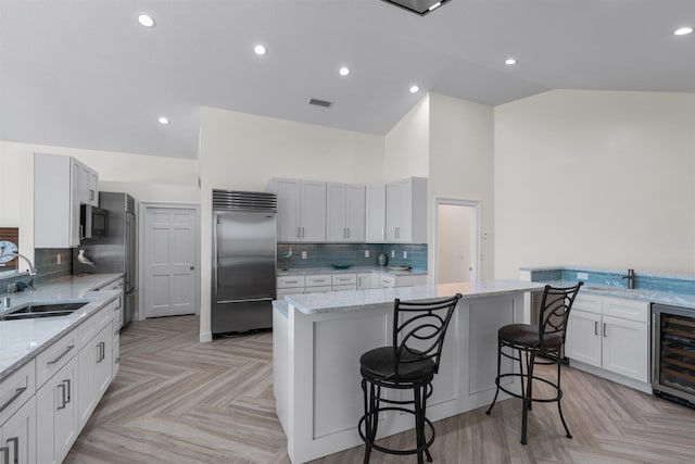 kitchen featuring appliances with stainless steel finishes, a breakfast bar area, a sink, and a center island