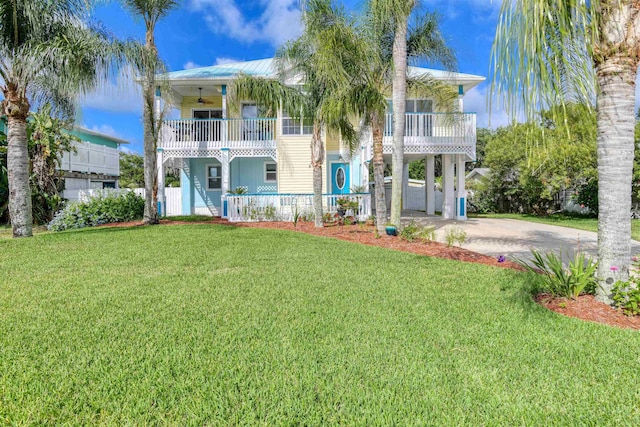 view of front of home featuring a front yard, a carport, a balcony, and ceiling fan