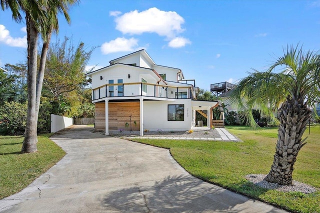 view of front of property featuring a balcony and a front lawn