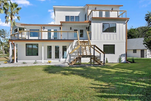 back of property with a lawn, a balcony, and french doors