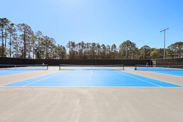 view of tennis court with basketball hoop