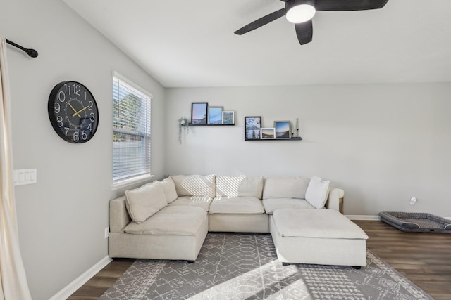 living room featuring dark wood-type flooring and ceiling fan