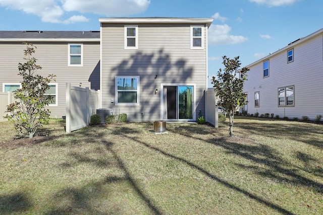 rear view of property with central AC unit and a lawn