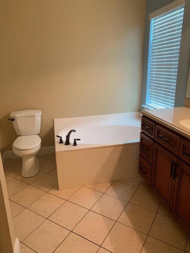 bathroom featuring tile patterned flooring, vanity, toilet, and a washtub