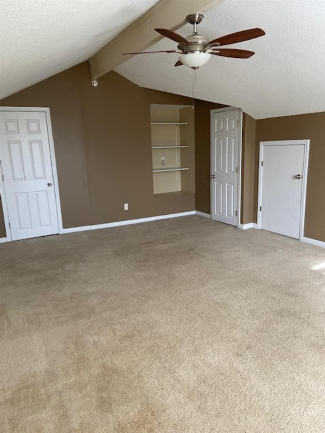 unfurnished living room featuring carpet flooring, vaulted ceiling with beams, and a textured ceiling