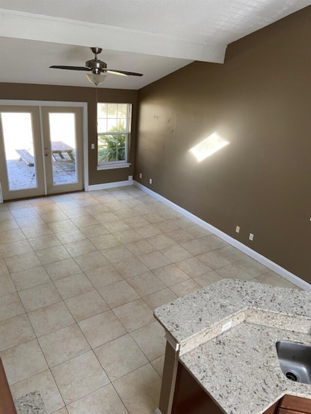 empty room with ceiling fan, light tile patterned floors, and french doors