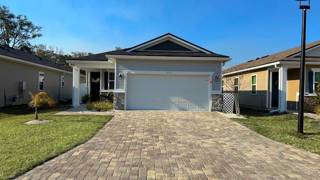 view of front facade with stone siding, a garage, decorative driveway, and a front lawn